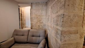 a living room with a couch against a stone wall at Poeta Iglesias 22 in Salamanca