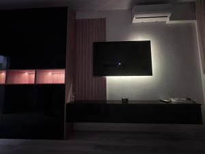 a living room with a flat screen tv on a wall at Luxury 1 bedroom apartment in Bucharest