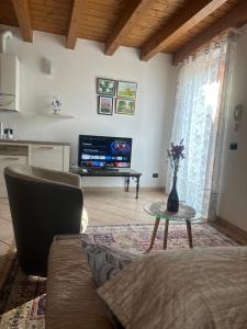a living room with a couch and a tv at Ely Hause in Calmasino