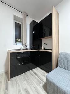 a kitchen with black cabinets and a bed in a room at Luxury 1 bedroom apartment in Bucharest