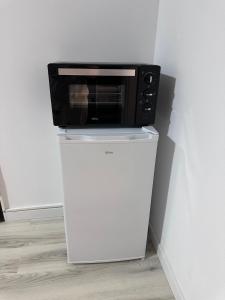 a microwave sitting on top of a white refrigerator at Luxury 1 bedroom apartment in Bucharest