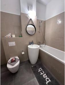 a bathroom with a toilet and a sink and a tub at Luxury 1 bedroom apartment in Bucharest