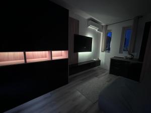 a living room with a flat screen tv on a wall at Luxury 1 bedroom apartment in Bucharest