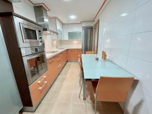een keuken met een tafel met stoelen en een magnetron bij Apartamentos Ciudad del Calzado in Arnedo