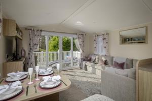 salon z kanapą i stołem w obiekcie Ribble Heights - Cosy Tree-Top Glamping Lodge with Balcony w mieście Longridge
