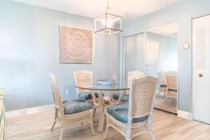 a dining room with a glass table and chairs at 239 Surf Song Resort in St. Pete Beach