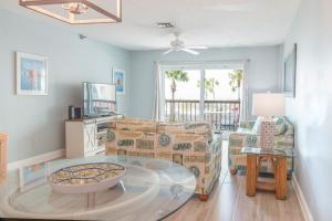 a living room with a couch and a table at 239 Surf Song Resort in St. Pete Beach