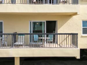 a balcony with chairs and tables on a building at 239 Surf Song Resort in St. Pete Beach