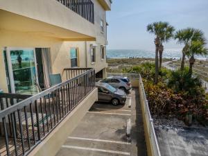 a balcony of a house with a car parked next to the ocean at 239 Surf Song Resort in St. Pete Beach