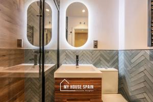 uma casa de banho com um lavatório e 2 espelhos em MyHouseSpain - Moderno apartamento en el centro em Madri