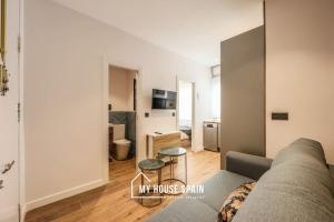 uma sala de estar com um sofá e uma mesa em MyHouseSpain - Moderno apartamento en el centro em Madri
