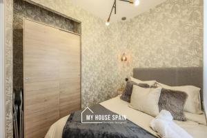 um quarto com uma cama e um grande armário de madeira em MyHouseSpain - Moderno apartamento en el centro em Madri