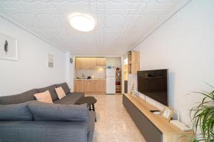 Una sala de estar con un sofá y un televisor. en Casita del Puerto 3, en Santa Pola