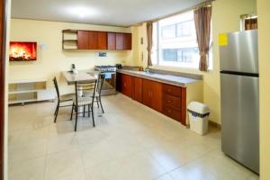 a kitchen with a table and chairs and a refrigerator at tourist house suites 2 in Otavalo