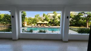 Zimmer mit Blick auf den Pool durch ein Fenster in der Unterkunft Diani Beachfront Flats in Ukunda