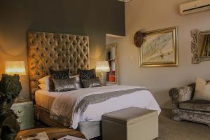 a bedroom with a large bed and a chair at Mymering Wine & Guest Estate in Ladismith
