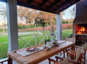 una mesa de madera en un porche con chimenea en Mon Rêve Estate en Ciudad del Cabo