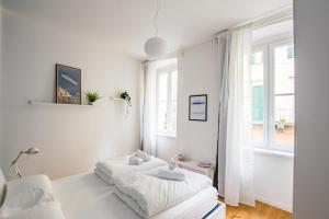 een witte slaapkamer met een bed en een raam bij G10 in Trieste