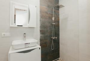 a bathroom with a shower with a sink and a mirror at Apartment 1905 in Tbilisi, Avlabari in Tbilisi City +75 photos
