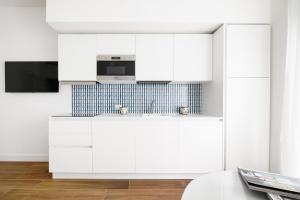 a kitchen with white cabinets and a microwave at Casa Maflogi in Sorrento