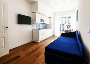a living room with a blue couch and a tv at Casa Maflogi in Sorrento +5 photos