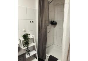 a bathroom with a shower with a shower curtain at City-Apartment Kreuzviertel-Lädchen mit gratis Parkplatz in Münster