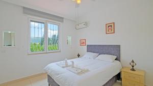 Un dormitorio blanco con una cama grande y una ventana. en Villa Estelle, en Fethiye 30 fotos más