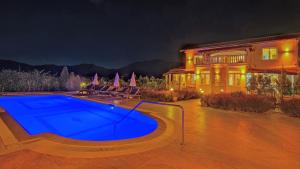 Una casa grande con piscina delante de ella. en Villa Estelle, en Fethiye