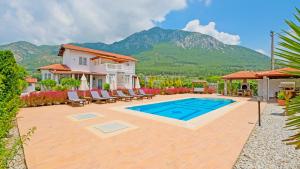 Un patio trasero con piscina y una casa. en Villa Estelle, en Fethiye