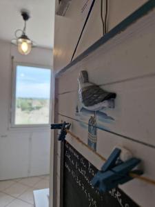 ein Vogel, der an einer Wand neben einem Schild sitzt in der Unterkunft Studio - Marina 4 - 17 allée des Pinons - 5-4 in Saint-Jean-de-Monts