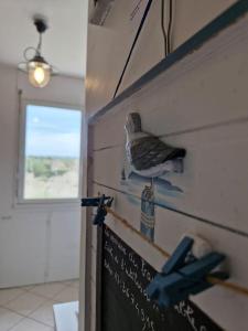 Un pájaro posado en una pared junto a un cartel. en Studio - Marina 4 - 17 allée des Pinons - 5-2, en Saint-Jean-de-Monts
