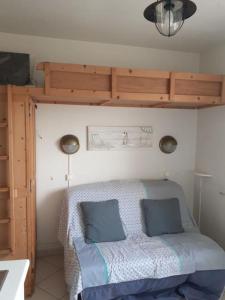 ein Schlafzimmer mit einem Bett mit zwei blauen Kissen in der Unterkunft Studio - Marina 4 - 17 allée des Pinons - 5-4 in Saint-Jean-de-Monts