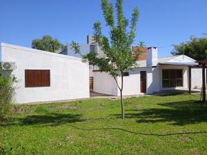 a white house with a tree in the yard at Pucará in Federación