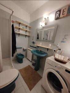a bathroom with a toilet a sink and a washing machine at Trebiano a casa dei nonni in Arcola