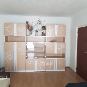 a room with a book shelf with trees on it at Apartman Trajan in Piešťany +11 photos