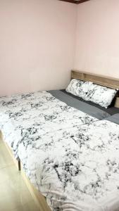 um quarto com uma cama com um edredão branco e preto em Bang Saen House: Friends/Family. em Ban Thai Don (1)
