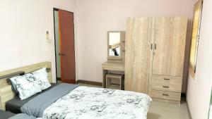 - une chambre avec un lit, une commode et un miroir dans l'établissement Bang Saen House: Friends/Family., à Ban Thai Don (1)