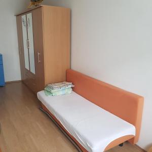 a bed sitting in a room with a cabinet at Apartman Trajan in Piešťany +4 photos