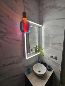 La salle de bains est pourvue d'un lavabo et d'un miroir. dans l'établissement Lounge garden sea relax, à Valence