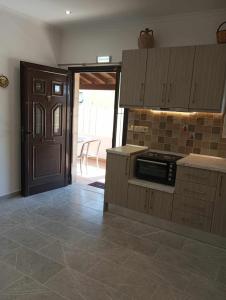 a kitchen with a stove and a door to a patio at Gerekos Studios and Apartments in Agios Georgios