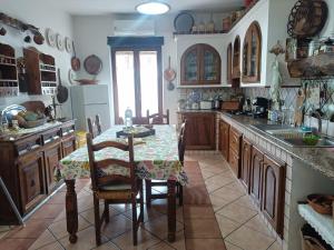 een keuken met een tafel met stoelen en een tafel en een tafel bij Casa Sa Hosta in Gavoi