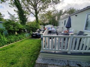 a porch with a white fence and an umbrella at 22 Washbrook Way in Ashbourne