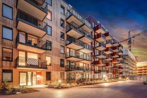 Demims Apartments Greater Oslo - Modern, Central & Stylish في Lorenskog: مبنى فيه بلكونات جنبه