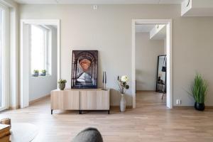 ein Wohnzimmer mit einem Couchtisch und einem Gemälde an der Wand in der Unterkunft Demims Apartments Greater Oslo - Modern, Central & Stylish in Lorenskog