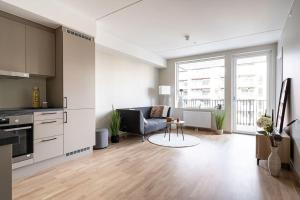 a kitchen and living room with a couch and a table at Demims Apartments Greater Oslo - Modern, Central & Stylish in Lorenskog