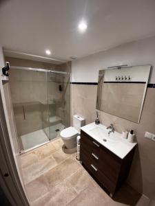 y baño con ducha, aseo y lavamanos. en Shanti’s Andalusian Rooms, en Málaga