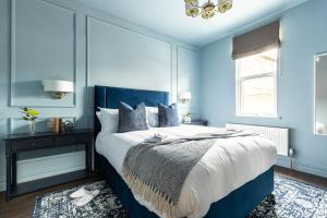 a bedroom with blue walls and a bed with a blue headboard at Emerald Park - with Games Room in Scarborough