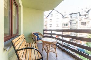 a balcony with two benches and a table and chairs at Apartament w Centrum in Międzyzdroje +3 photos