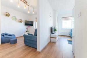 Apartament w Centrum في مينززدرويه: غرفة معيشة مع أريكة زرقاء وتلفزيون
