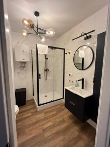 La salle de bains est pourvue d'une douche et d'un lavabo. dans l'établissement Apartament w Centrum, à Międzyzdroje